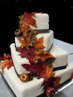 a three tiered cake decorated with fall leaves