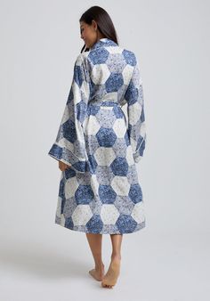 The charming Corina robe is cut from our inimitable butter soft satin and adorned with an interesting blue patchwork print. This oversized kimono-inspired robe boasts fluted sleeves and a detachable belt, creating a flattering silhouette. Contrast piping on the cuff and neck, complete this effortlessly feminine piece.   Cool machine wash only. Wash inside out and with similar colours 100%  Cotton   Cool machine wash only. Wash inside out and with similar colours Blue Printed Silk Kimono, Blue Kimono With Kimono Sleeves For Daywear, Blue Floral Print Robe For Home, Blue Floral Print Kimono For Loungewear, Blue Kimono Sleeve Robe For Home, Blue Spring Robe For Home, Blue Robe With Kimono Sleeves For Home, Blue Home Robe For Spring, Blue Spring Home Robe