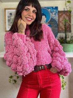 a woman in pink sweater and red pants