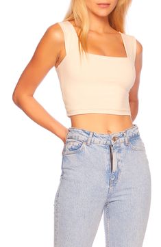 a woman with blonde hair wearing jeans and a cropped top is posing for the camera