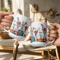 two women holding coffee mugs in their hands with flowers and plants on the cups