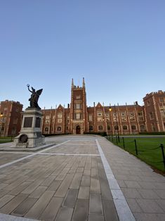 a large building with a statue in the middle of it's courtyard and grass on both sides