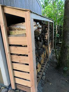 logs are stacked in the back of a shed