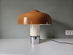 Amazing and rare large Italian mushroom desk lamp designed by Luigi Massoni for Harvey Guzzini, Italy and made in Meblo, Yugoslavia in 70s. Rare caramel color of the shade. It has a standard European two-pin plug, easily used with an adapter worldwide, takes 3 bulbs E14, 2 x 40 Watt maximum (or LED). Both lit or unlit you will have a spectacular space age lamp. Dimensions: Height: 44 cm (17.3") Diameter: 44 cm (17.3") Condition: Excellent vintage working condition. If you have any questions feel 70s Space Age, Harvey Guzzini, Luigi Massoni, Table Lamp Vintage, Desk Lamp Design, Lamp Vintage, Vintage Lamp, Design Table, Caramel Color