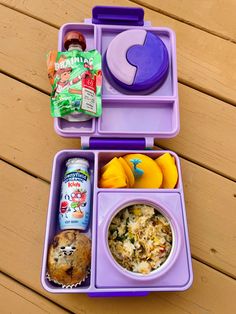 a purple lunch box filled with food on top of a wooden table