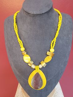 Add a pop of color to your jewelry collection with this vintage statement necklace in yellows and golds. The necklace measures 18-20 inches in length and features a combination of plastic, metal, and lucite materials. With beads of multiple styles, it's perfect for adding a touch of retro style to any outfit. The necklace is designed in a statement style, making it a bold and eye-catching piece that is perfect for special occasions or dressing up an everyday outfit. Whether you're a vintage jewelry collector or just looking for a unique piece to add to your collection, this necklace is sure to impress. Vintage Collectibles #00227 Adjustable Yellow Necklace With Wooden Beads, Adjustable Yellow Necklaces With Wooden Beads, Adjustable Yellow Wooden Beads Necklace, Vintage Yellow Necklace With Colorful Beads, Yellow Beaded Costume Jewelry Necklace, Yellow Beaded Costume Jewelry Necklace For Gift, Yellow Costume Jewelry Beaded Necklace For Gift, Vintage Yellow Resin Jewelry, Vintage Yellow Beaded Necklaces As Gift