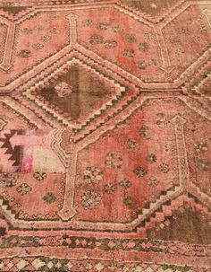 an old rug with many different colors and patterns on the ground, including pinks