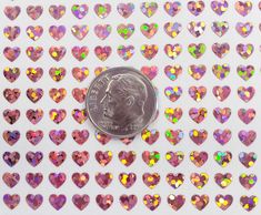 a penny sitting on top of a table covered in lots of heart shaped confetti