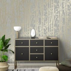 a living room scene with focus on the dresser and wallpapered area that has bamboo trees