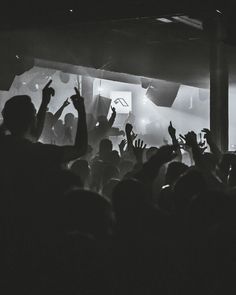 black and white photo of people at a concert with their hands up in the air