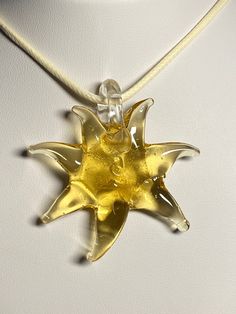 yellow golden glass star, sun pendant, necklace, choker, yellow star, golden sun -PU ivory leather fully adjustable cord choker to long each pendant is handmade and unique.  This color goes with any clothing pendant height: 5.25 cm, 2 1/16 inches +/- 2mm and width: 5 cm, 2 inch +/- 2mm cord length: fully adjustable, choker to 28 inches/71 cm comes with a gift bag designed for someone whom is looking for a unique necklace Please have a look at the other items in my store. I ship all multi-item pu Handmade Adjustable Star Necklace, Adjustable Sun-shaped Jewelry For Gifts, Handmade Yellow Star-shaped Jewelry, Handmade Yellow Star Jewelry, Adjustable Yellow Round Pendant Necklace, Adjustable Yellow Necklace With Round Pendant, Cord Choker, Unusual Clothes, Yellow Star