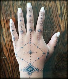 a person's hand with tattoos on it and stars in the sky above them