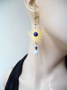 For these earrings I started with a svarowski rhinestone washer then a small chalcedony. On the brass filigree representing the bee I set a lapis lazuli cabochon then chalcedony, lapis lazuli rhinestone washer and chalcedony to finish. Unique piece Metael Thank you for your visit! Handmade Gold Earrings With Chalcedony, Gold Lapis Lazuli Jewelry With Cabochon, Elegant Lapis Lazuli Gemstone Earrings, Elegant Lapis Lazuli Oval Cabochon Jewelry, Yellow Gold Lapis Lazuli Cabochon Jewelry, Luxury Blue Lapis Lazuli Earrings, Bee Earrings, Lapis Lazuli, Unique Pieces