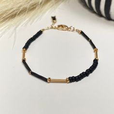 The combination of black and gold adds an understated touch luxury to your wrist. This bracelet consist of a mix of matte black beads  surrounding some pops of gold. Wear alone or stack it! - 3mm width - Adjustable - 6 inches plus 1.5 inch gold filled extender chain * Each order will come with an eco-friendly branded cloth pouch or black kraft box. I try to consolidate orders with multiple items into one bag or box to reduce landfill waste.  However, please let me know if the jewelry is for a gift so they can be packaged accordingly.  All ordered will be packed with reused/ recycled materials.  *Please see shop announcement section for care instructions. Adjustable Matte Gold Minimalist Bracelet, Adjustable Black Bracelets With Gold Beads, Minimalist Black Matte Finish Jewelry, Minimalist Black Beaded Bracelets For Everyday, Minimalist Black Beaded Bracelets, Modern Black Beaded Bracelets For Everyday, Trendy Black Beaded Bracelets With Tiny Beads, Minimalist Black Jewelry With Gold Beads, Everyday Black Beaded Bracelets