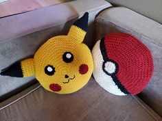 two knitted pikachu pillows are sitting on a couch next to each other