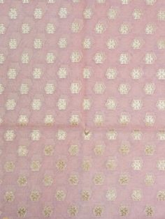 an old pink and gold cloth with small white flowers on it