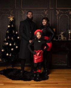 a man and two women standing in front of a christmas tree