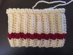 a white and red crochet purse sitting on top of a table