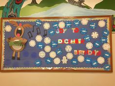 a bulletin board is decorated with animals and snowflakes on the wall above it