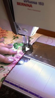 a woman using a sewing machine to sew flowers