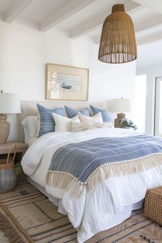 a bedroom with white walls and blue bedding