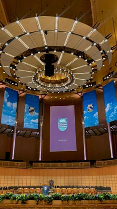 an empty auditorium with several large screens on the wall