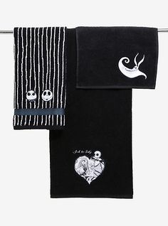 three towels hanging on a clothes line with embroidered faces and hearts in the middle one is black and white