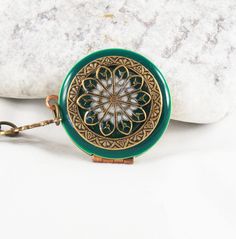 Emerald green filigree locket pendant. This locket is the perfect gift for her. Beautiful filigree handcrafted brass locket with a glass like resin finish. The locket measures approx 31mm and is hanging on an antiqued brass chain. Please choose your length at checkout.   Inside of the locket are two spaces for photo's etc..  The locket will arrive in a little gift box  ready for giving. Thanks for looking. Green Brass Jewelry As Gift, Green Vintage Charm Jewelry Gift, Green Vintage Charm Jewelry For Gift, Green Brass Jewelry For Gifts, Green Brass Jewelry For Gift, Green Brass Jewelry Gift, Green Antique Finish Jewelry For Gift, Green Locket Jewelry, Green Vintage Charm Brass Jewelry