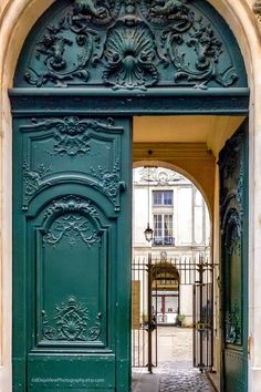 an ornate green door is open to the street