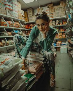 a woman sitting in a grocery store with her hand on her face