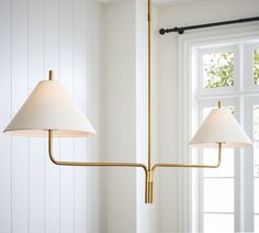 two lamps hanging from a ceiling in front of a window