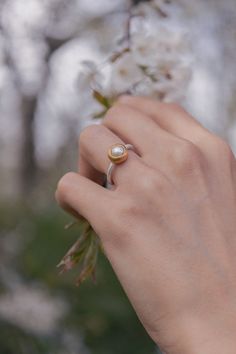 This exquisite pearl ring features a lustrous pearl nestled in a warm gold bezel setting, complemented by a sleek silver band. The harmonious combination of gold and silver adds a modern twist to this timeless design, perfect for both everyday wear and special occasions. Pair this ring with matching pearl earrings or a delicate gold and silver bracelet to create a cohesive and elegant look that highlights its unique charm. Sterling silver   Gold Vermeil  Garnet  To properly care for your silver Natural Pearl Ring, Gold And Silver Bracelets, Forever Jewelry, Business Idea, Natural Pearl, Jewelry Ring Box, Silver Jewelry Handmade, Delicate Rings, Watch Necklace