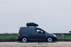 a van parked on the side of a road with a bench in the back ground