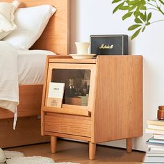 a bed room with a neatly made bed and a book stand on the floor next to it