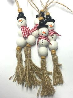 three snowman ornaments hanging from twine