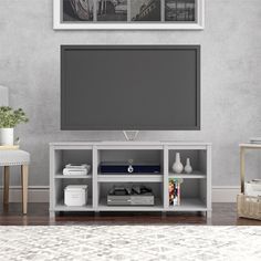 an entertainment center with a large flat screen tv on top of it's stand