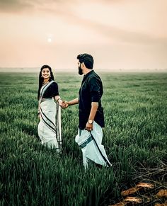 a man and woman holding hands in a field