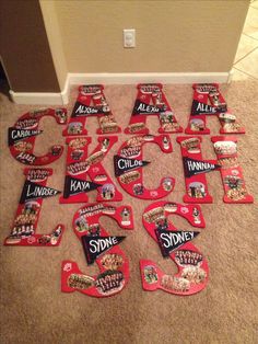 the letters are made out of candy bars and have been placed on the floor to spell out their names