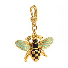 a gold and black bee charm on a chain with an ornate design, sitting on a white background