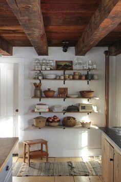 a kitchen with wooden shelves filled with dishes