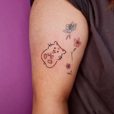 a woman's arm with a tattoo on it that has a cat and flowers