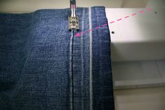 the sewing machine is stitching through some blue jeans with pink lines on it's side