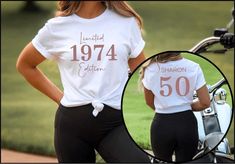 two women in matching shirts standing next to a motorcycle