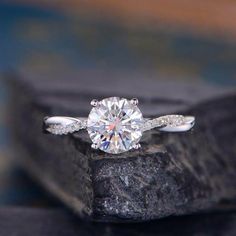 a diamond ring sitting on top of a rock