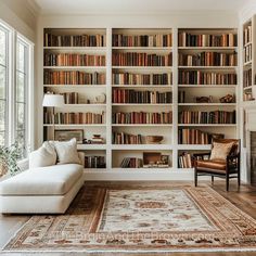 a living room filled with lots of books on top of a white book shelf next to a fire place