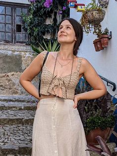 a woman standing in front of some steps with her hands on her hips and looking up at the sky