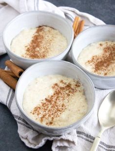 three bowls filled with oatmeal and cinnamon on top of a white towel