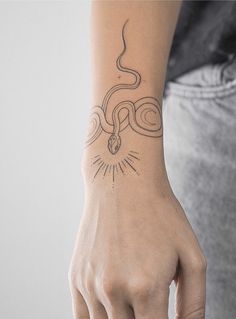 a woman's arm with a tattoo on it and a snake in the middle