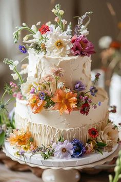 a three tiered cake with flowers on top