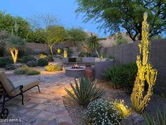 an outdoor patio and fire pit surrounded by plants